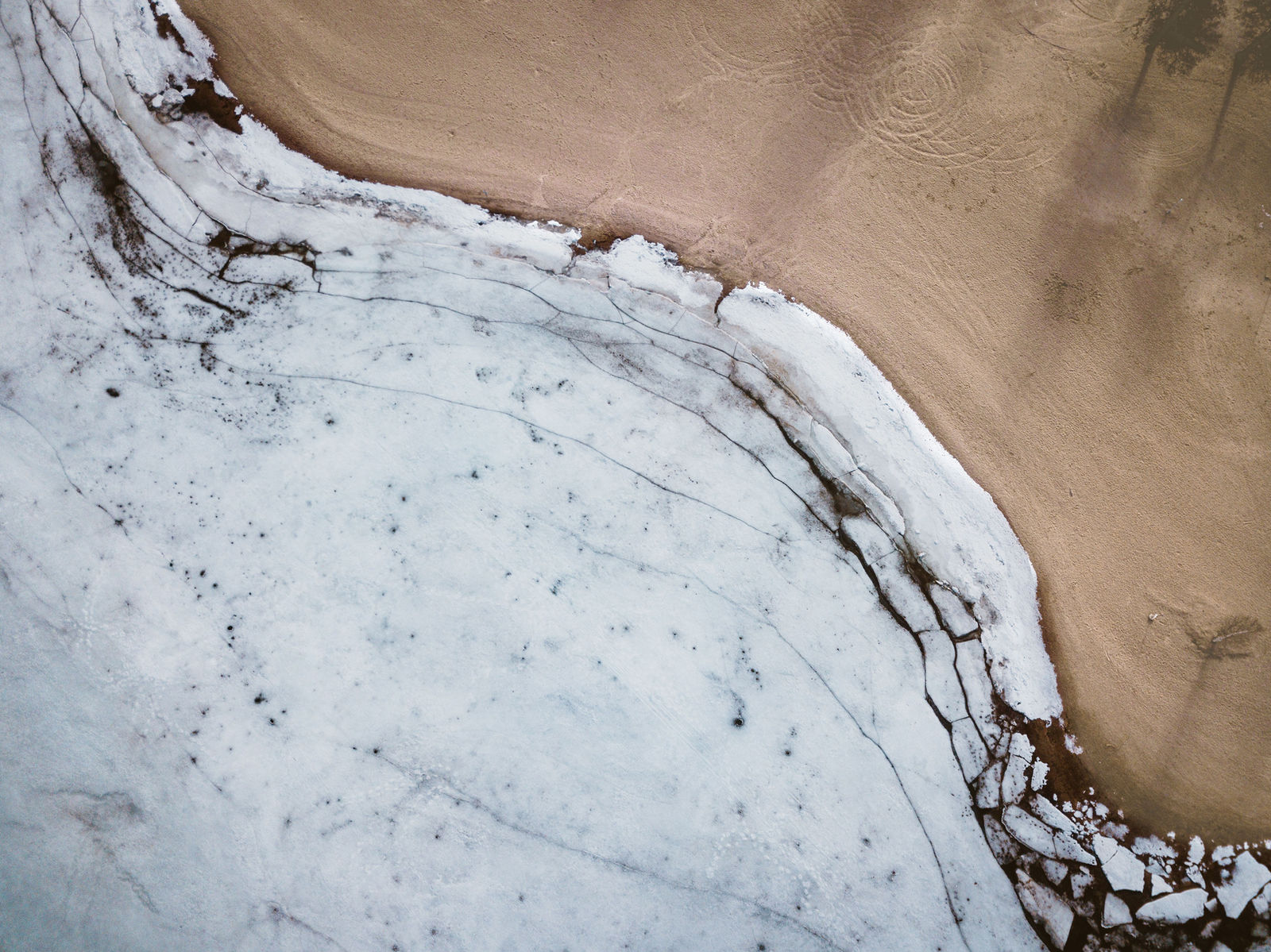 Abstrakte helle Struktur auf einer sandfarbenen Fläche.